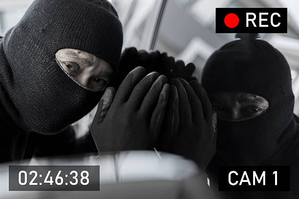 istock Masked thief caught on surveillance camera at night peeking through window during attempted burglary 2217050181