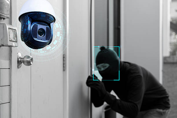 Smart surveillance camera detecting masked thief breaking into door, concept of AI security and crime prevention