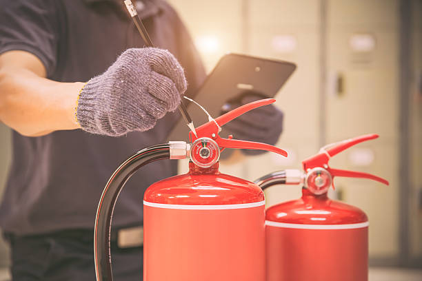 istock Fire extinguisher, Engineer inspection checking pressure gauge level fire extinguishers tank for protection and prevent emergency and safety rescue and alarm system training. 2217051787