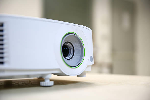 Modern video projector at business conference or lecture in office. Projector on wooden table indoors