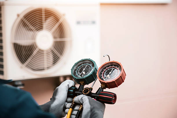 istock Mechanic air conditioner technician using manifold gauge checking refrigerant for filling home air conditioning and air duct cleaning and maintenance outdoor compressor unit. 2217051910