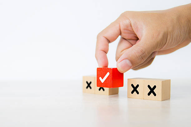 istock Hand choose check mark on cube wooden toy block stack with cross symbol for true or false changing mindset or way of adapting to change leader and transform quiz answer and poll concept 2217053016
