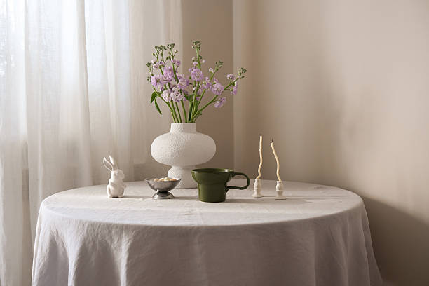 istock A beautifully easter serene table arrangement featuring vibrant flowers, elegant green cup of coffee, ceramic rabbit, and minimalistic candles on round table. 2217054037
