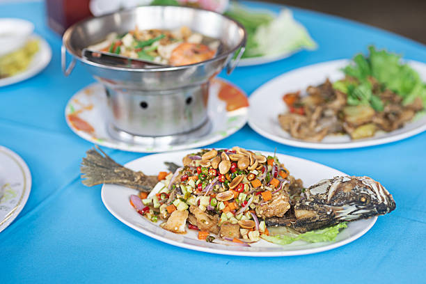 Fried fish with herbs placed on a white plate ready to be eaten.