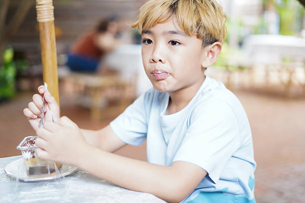 Close-up Boy eating cake in a cafe
