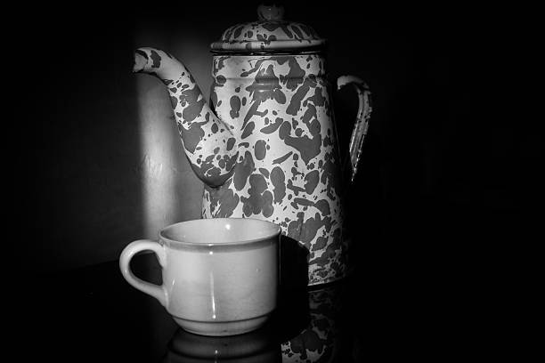 istock Vintage enamel teapot and cup in moody light 2217060001