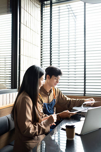 istock Business Partners Collaborating. Young professionals reviewing documents and digital content in a modern office. 2217063211