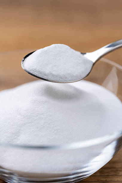istock Scooping Baking Soda Powder from Glass Bowl on Wooden Table with Spoon 2217065083