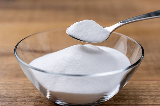 istock Scooping Baking Soda Powder from Glass Bowl on Wooden Table with Spoon 2217065109