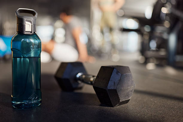 Water bottle and dumbbell in a gym.