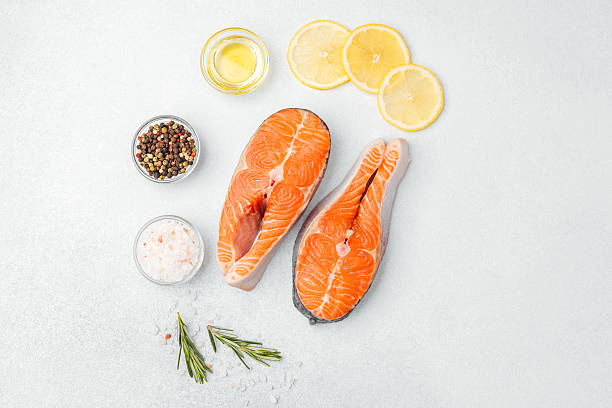 istock Fresh salmon fillets with lemon, herbs, and spices ready for cooking 2217067924