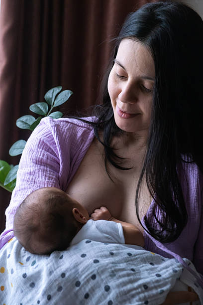 Mother Breastfeeding Baby by Window