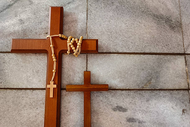 istock Two wooden crosses and a rosary rest on a marble-tiled surface. 2217070581