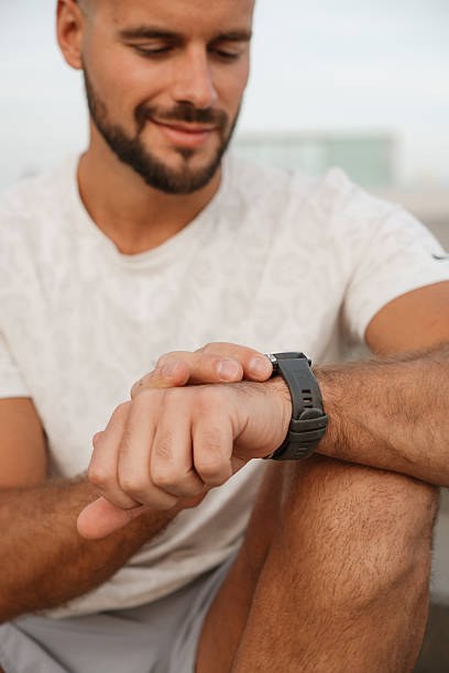 istock Sportsman checking time on smartwatch during training break 2217071815