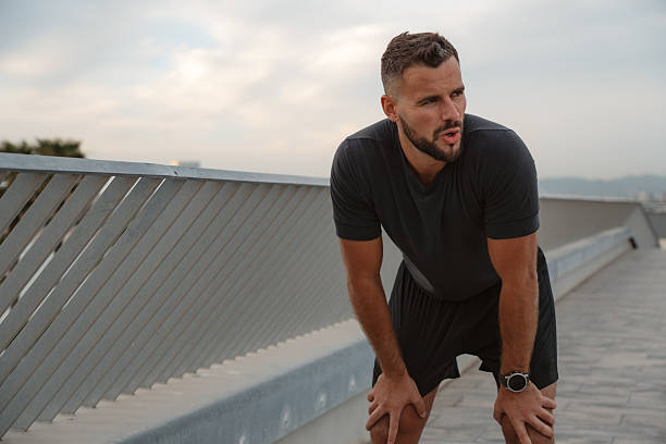 istock Tired sportsman resting after running on bridge 2217072239