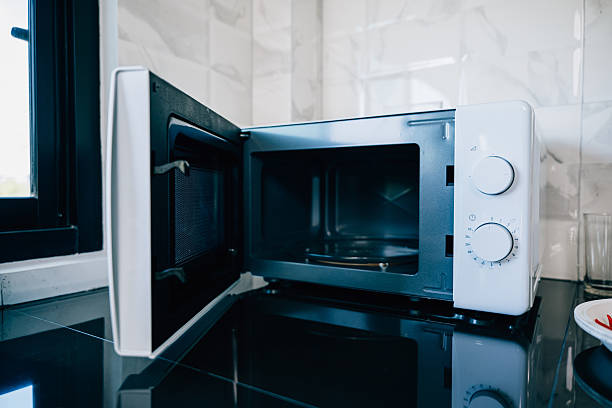 istock A modern kitchen setting showcasing an open microwave oven door 2217073916