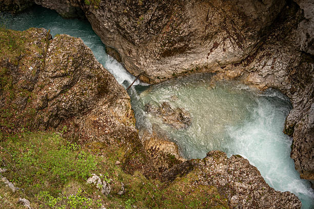 istock Dramatic Narrow Canyon In Leutaschklamm Gorge: Crystal-Clear Turquoise Mountain Stream Winding Through Steep Rocky Cliffs Surrounded By Moss-Covered Walls And Lush Greenery In Tyrol, Austria 2217075018