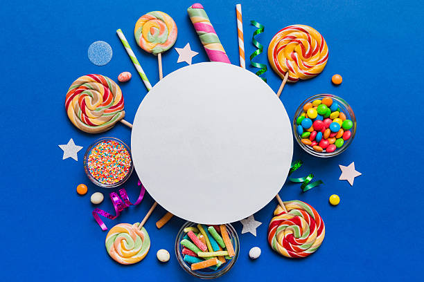 istock Flat lay holiday composition. Paper blank, lollipop, birthday decorations on Colored background. Top view, copy space for text 2217075763