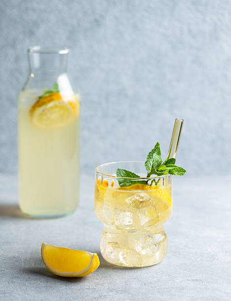 istock Fresh drink lemonade with lemon, mint and ice in glass on a blue background with bottle. 2217076809
