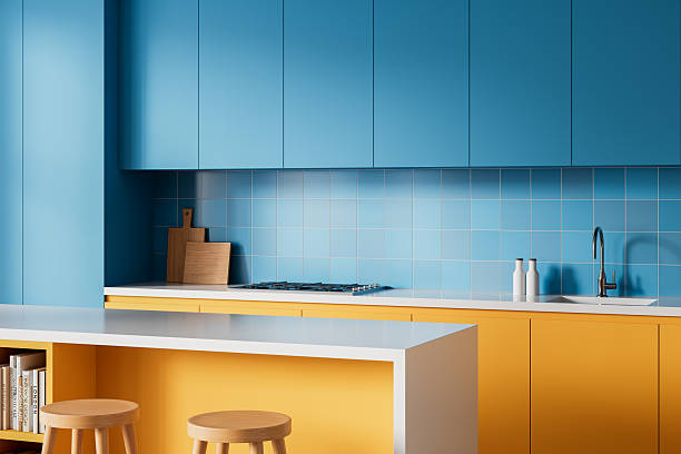 istock Modern interior kitchen design with blue cabinets and yellow drawers, featuring minimalist decor and clean countertop on soft background. 3D Rendering 2217077608