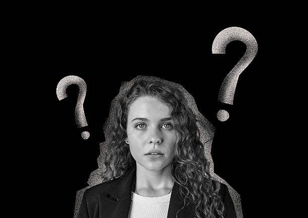 istock Young woman with curly hair expressing confusion, surrounded by question marks in a creative design 2217078004