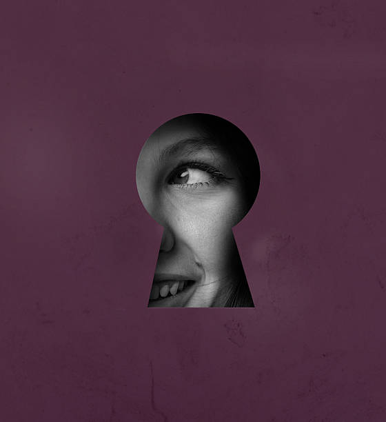 istock View through a keyhole reveals a smiling face, showcasing curiosity and intrigue in a vibrant setting 2217078254