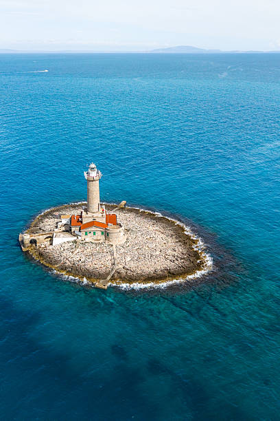 istock Porer Lighthouse on its rocky island, surrounded by endless deep-blue sea, with distant land faintly visible on the horizon 2217087852