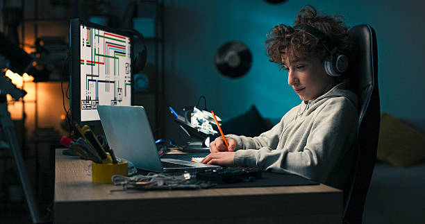 istock Focused and calm, the student combines laptop research with sketching in his notebook. He plans his school project in the evening, reflecting on its appearance. 2217088052