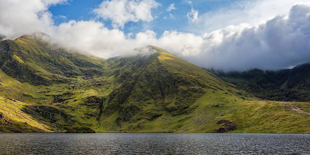 istock Lough Callee showcases stunning emerald hills enveloped in clouds, creating a serene natural vista. The calm waters mirror the landscape, highlighting Ireland's scenic charm. 2217088126
