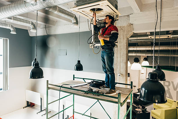 istock Technician repairs ventilation system in commercial building during daylight hours 2217089648