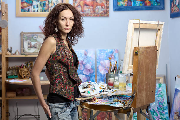 Young female artist working on a painting in her studio
