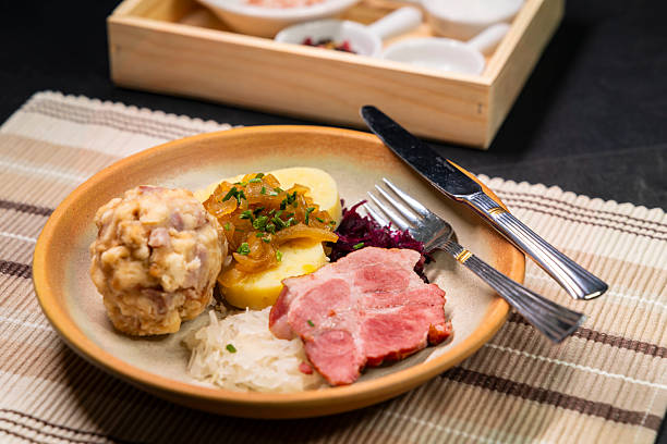 istock Bavarian dumplings with roasted pork, sauerkraut and potato dumpling lying on a plate 2217093372