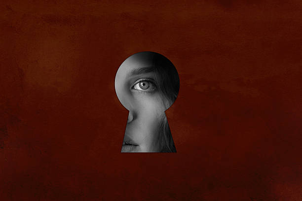 istock Mystical view through a keyhole revealing a woman's eye and emotion on a textured background 2217094556
