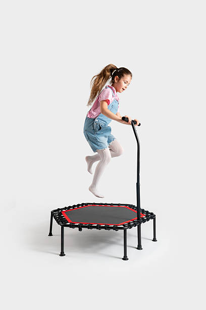 istock little girl jumping on trampoline on white background 2217099110