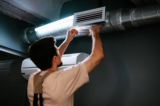 istock Worker installs air vent in modern indoor space during renovation process in urban environment 2217099388