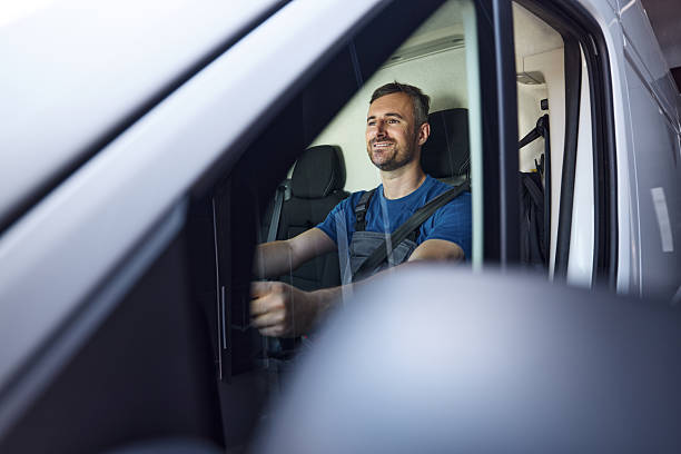 istock Happy delivery man driving a van. 2217099768