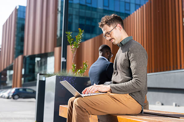 istock Young professional using a laptop outdoors on a sunny day 2217099920
