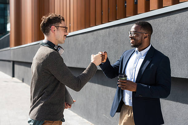 istock Two colleagues exchanging a fist bump outdoors on a sunny day 2217099974