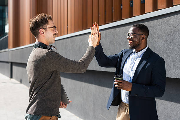 istock Two colleagues exchanging a high-five outdoors on a sunny day 2217099977