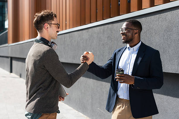 istock Two colleagues greeting each other outdoors with a handshake 2217099978