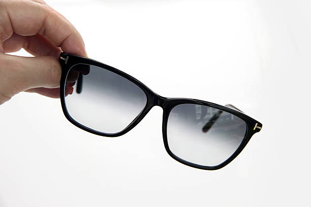 istock Summer black sunglasses with gradient lenses in hands on white background 2217103156
