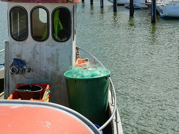 istock Old Fishing Boat with Green Net Barrel 2217103463