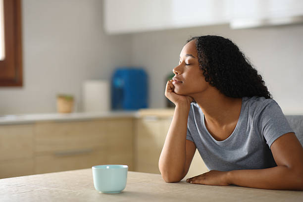 istock Black woman is relaxing in a kitchen at home 2217104415