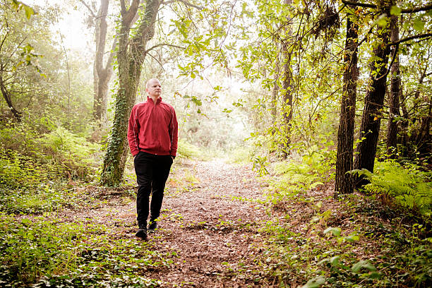 istock Man walking on a path in the woods enjoying nature 2217107619