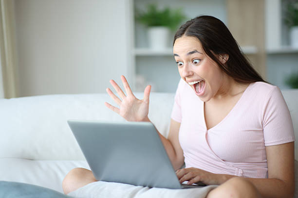 istock Amazed woman watching astonishing content on laptop 2217107840