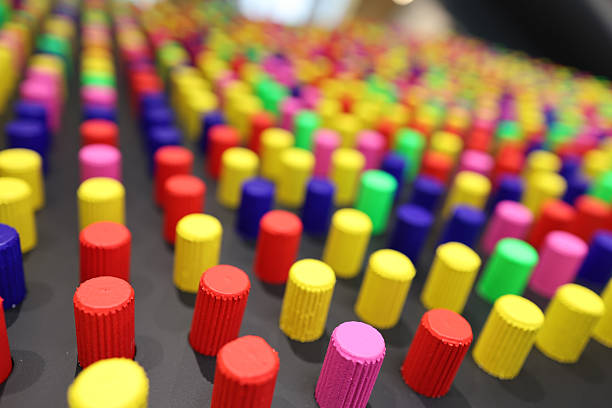 abstract installations featuring colorful cylindrical and circular dots arranged in precise geometric patterns on flat and vertical surfaces.