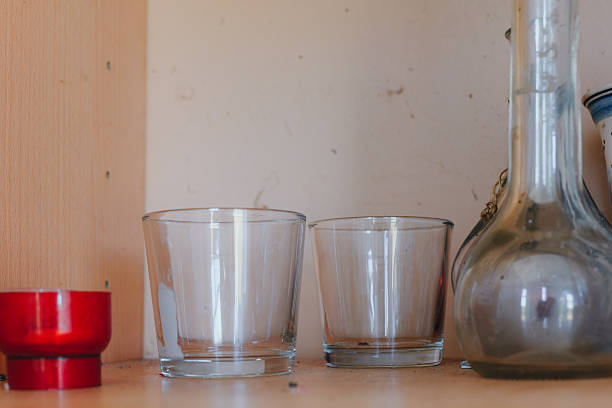 Glassware collection arranged on a rustic wooden shelf with an artistic touch and warm lighting in a cozy setting stock photo