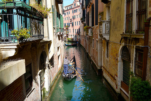 Venice, Italy - 05 May 2025 : Gondolas and river boats are a popular mode of transport for tourists and locals in Venice.