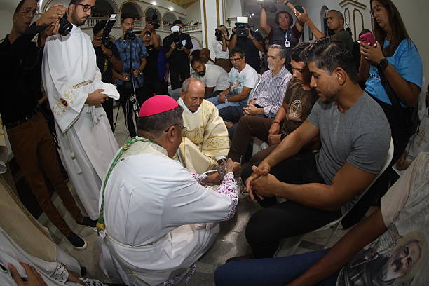 serrinha, bahia, brazil - april 17, 2025: catholic bishop performs the foot washing ceremony during the fogareu procession mission in the city of Serrinha.