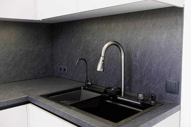 istock Modern kitchen with sleek faucet and dark countertops showcases contemporary design elements 2217111888